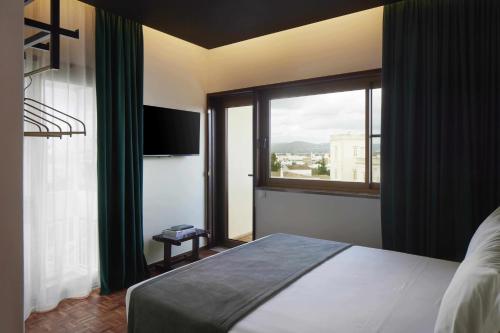 a bedroom with a bed and a large window at Alto House Faro AL de Assinatura Modernista in Faro