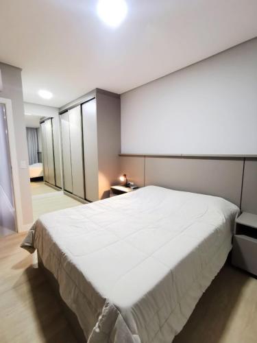 En eller flere senge i et værelse på Apartamento 3 Suítes - Itapema