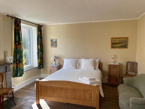 Un dormitorio con una cama y un sofá y una ventana. en Grammelot, en Beauraing
