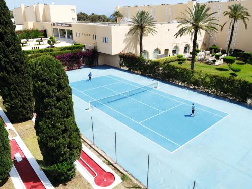 two people playing tennis on a tennis court at TUI BLUE Scheherazade Adults Only - All Inclusive in Sousse