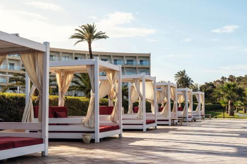 a row of white beds in front of a building at TUI BLUE Scheherazade Adults Only - All Inclusive in Sousse