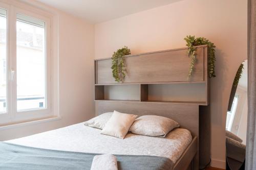 1 dormitorio con 1 cama con 2 almohadas en Charmant appartement 4 personnes en centre-ville, en Caen