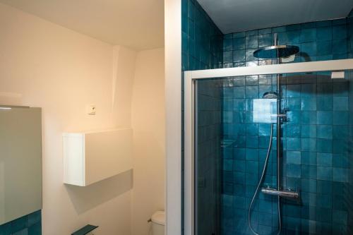 une salle de bain avec douche aux carreaux bleus dans l'établissement Charmant appartement 4 personnes en centre-ville, à Caen