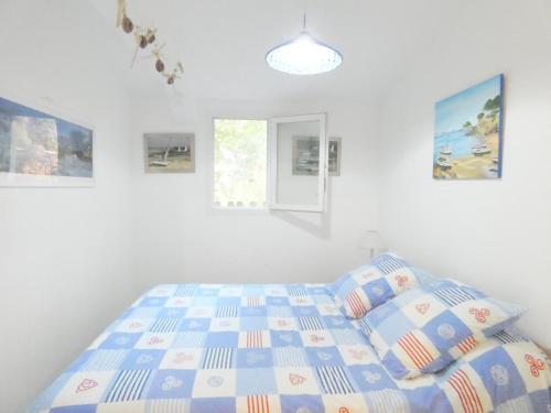 Un dormitorio blanco con una cama y algunas fotos en Les sources, en Gourbera