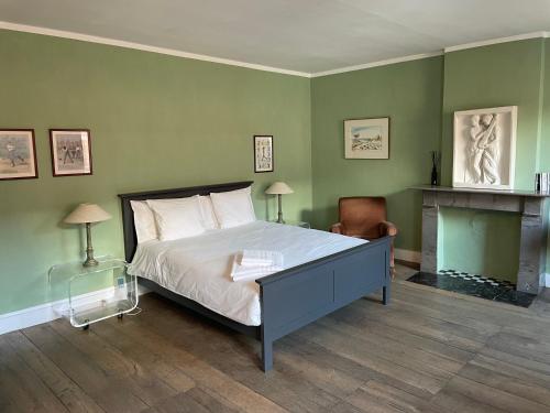 - une chambre avec un lit aux murs verts et une cheminée dans l'établissement Grammelot, à Beauraing
