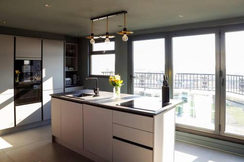 a kitchen with white cabinets and a large window at Modern 2 Bed 2 Bath - Plymouth in Plymouth