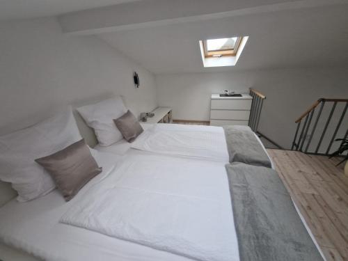 a large white bed in a room with a window at Rhön Apartments in Frankenheim