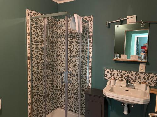 La salle de bains est pourvue d'un rideau de douche et d'un lavabo. dans l'établissement Grammelot, à Beauraing