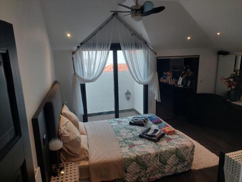 a bedroom with a bed and a large window at Casa Pico Musica in Funchal