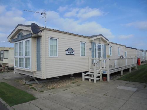 a mobile home with a porch and a deck at Golden palm : Vogue 6 Berth, Central Heated, Enclosed Veranda in Chapel Saint Leonards
