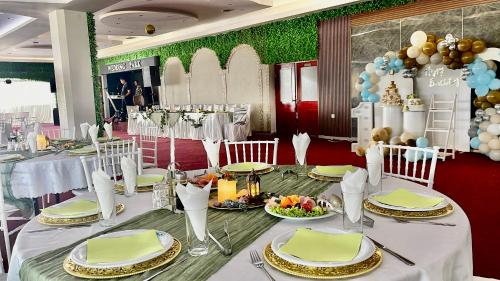 a table set up for a party with white tables and chairs at Hotel Park in Negotino