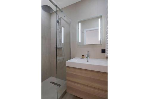 une salle de bain avec un lavabo et une douche dans l'établissement Luxueuses Suites - Arc de Triomphe - Trocadéro, à Paris