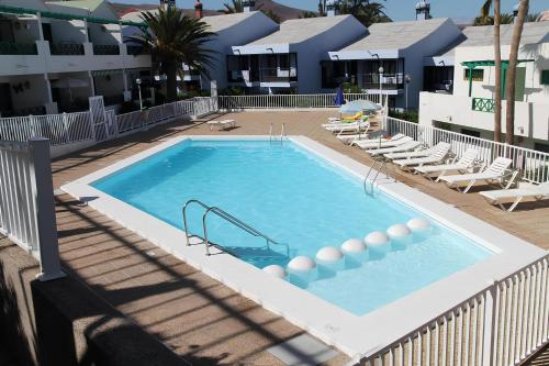 een zwembad met glijbaan in een resort bij Bonito apartamento cerca la playa in San Bartolomé