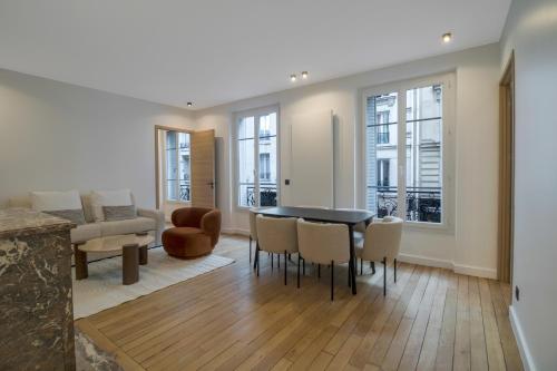 un salon avec une table et des chaises de salle à manger dans l'établissement Luxueuses Suites - Arc de Triomphe - Trocadéro, à Paris