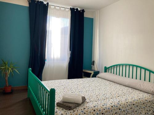 - une chambre avec un lit bébé vert et une fenêtre dans l'établissement L’appartement de Manon, à Montauban