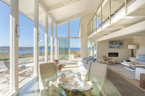 een woonkamer met een glazen tafel en ramen bij 3911 Point Lobos View home in Carmel