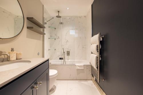 ein Bad mit einem Waschbecken, einem WC und einer Dusche in der Unterkunft The Marylebone Escape - Lovely 1BDR Flat in London