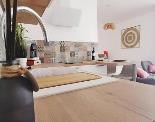 a kitchen with a table with a wooden counter top at Gîte Luxe DOUCE HARMONIE SPA & MASSAGES Offre Spéciale in Villemoustaussou