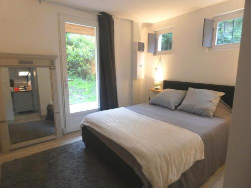 a bedroom with a bed and a large window at Gîte de linxe in Linxe