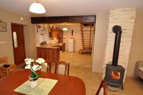 a kitchen and dining room with a wood stove at Apartament Pod Garbem in Bachórz
