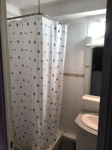 une salle de bain avec un rideau de douche avec des toilettes et un lavabo dans l'établissement Studio cosy cœur de Font Romeu, à Font-Romeu-Odeillo-Via