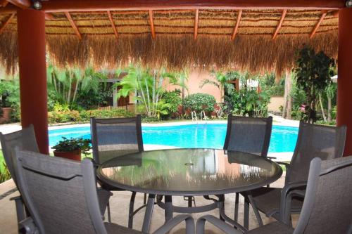 a patio with a table and chairs and a pool at Villa Familiar en exclusivo condominio playacar in Playa del Carmen