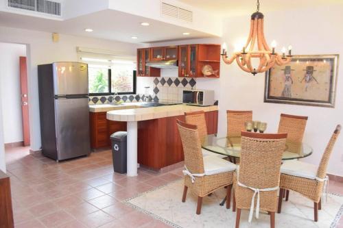a kitchen with a table and chairs and a refrigerator at Villa Familiar en exclusivo condominio playacar in Playa del Carmen