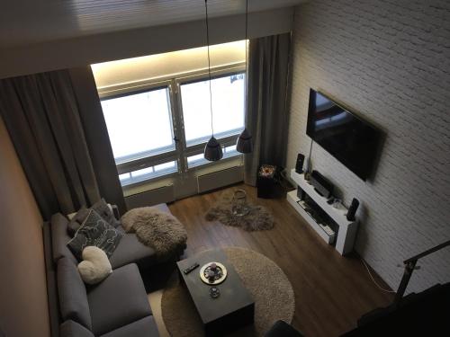 een woonkamer met een bank en een tv bij Peipon pesä in Syöte