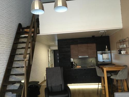 a living room and kitchen with a staircase in a loft at Peipon pesä in Syöte