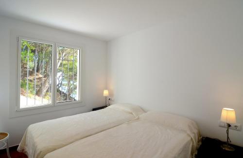 レスタルティットにあるApartamento Blau Mar Cap de la Barraの白いベッドルーム(ベッド1台、窓付)