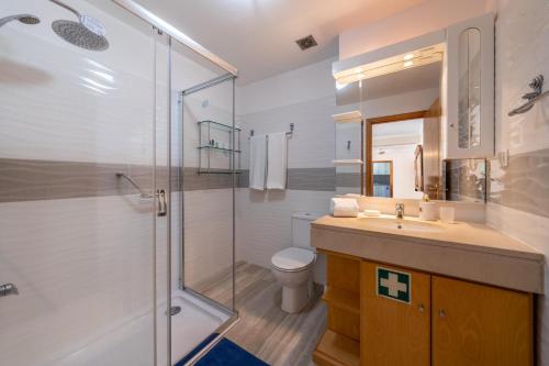 ein Bad mit einer Dusche, einem Waschbecken und einem WC in der Unterkunft Harmonia Apartment by Atlantic Holiday in Machico
