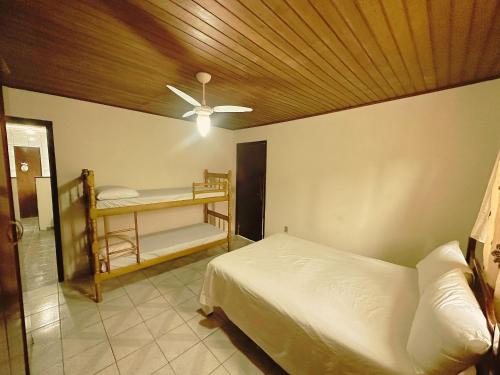 a bedroom with a bed and a ceiling fan at Condomínio Fazenda Garatucaia in Angra dos Reis