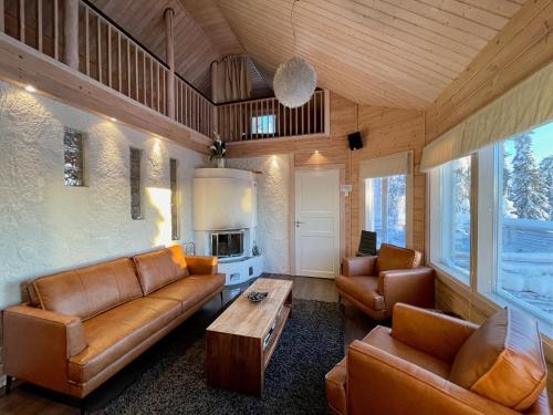 een woonkamer met bruin lederen meubilair en een tafel bij Hietavilla Aurora in Ruka