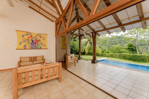 una sala de estar de planta abierta con piscina en una casa en Two Bedroom Villa - Tamarindo, en Islita