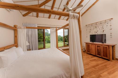 1 dormitorio con 1 cama y TV de pantalla plana en Two Bedroom Villa - Higueron, en Islita