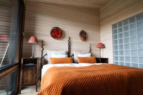 una camera con un letto e una coperta arancione di Ruka Peak - Boutique Hotel & Restaurant a Ruka