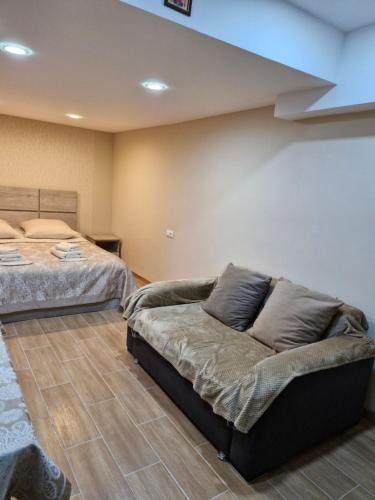 1 dormitorio con 2 camas y sofá en Guest house Lana, en Tiflis