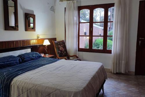 a bedroom with a bed and a chair and a window at Tierra del sol Apart in La Banda