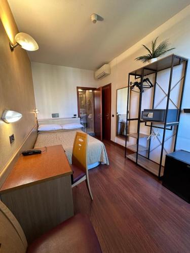 a room with a bedroom with a bed and a desk at Hotel Aspromonte in Milan