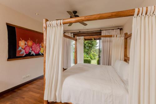 - une chambre avec un lit à baldaquin et une fenêtre dans l'établissement Three Bedroom Villa - Estrella, à Islita