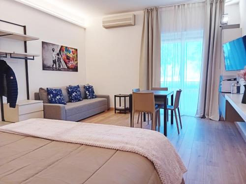 a living room with a bed and a dining room at Appartamento con Terrazza Fronte Mare in Riccione