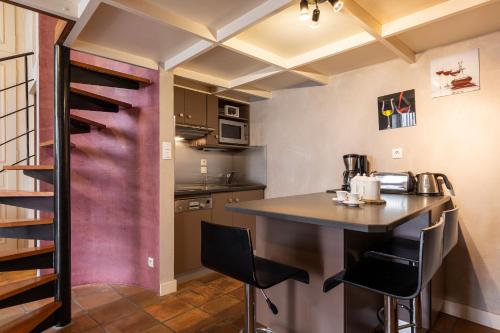 une cuisine avec un comptoir et un bar avec des chaises dans l'établissement DIFY Tour Rose, à Lyon