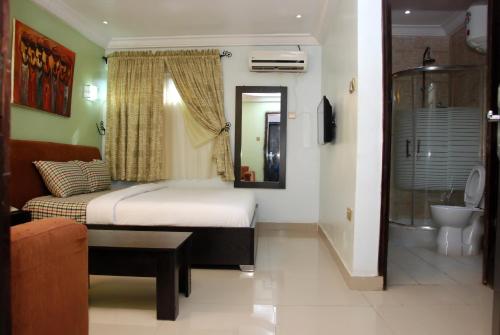a bedroom with a bed and a bath room at BEN AUTO Hotel in Lagos