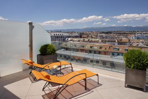 a balcony with two tables and a view of a city at Beau-Rivage Genève in Geneva