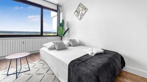 ein Schlafzimmer mit einem Bett und einem großen Fenster in der Unterkunft ICE - Proche Gare - Wifi Gratuit - Baignoire in Gaillard