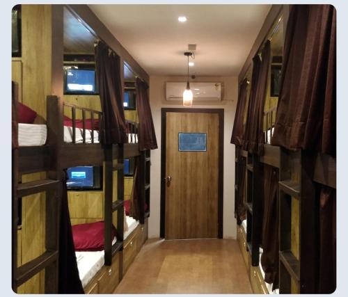 a hallway with three bunk beds and a door at Hilal dormitory in Mumbai