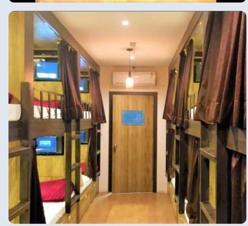 een kamer met 2 stapelbedden en een deur bij Hilal dormitory in Mumbai