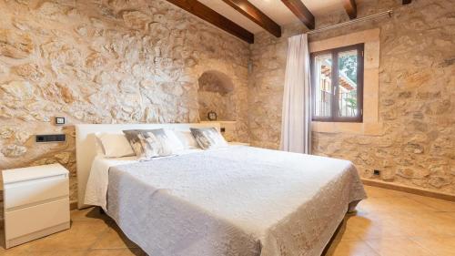 a bedroom with a large bed in a stone wall at Agroturismo son Calo in Petra
