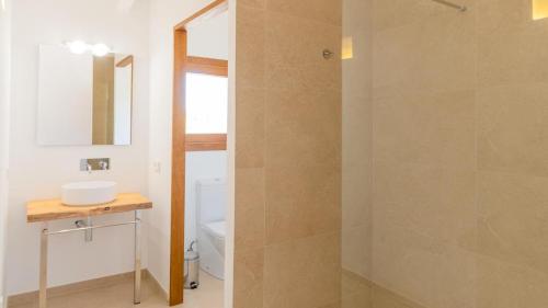 a bathroom with a shower with a sink and a mirror at Agroturismo son Calo in Petra