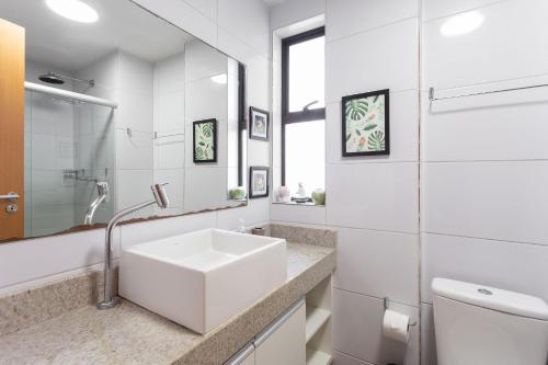 a white bathroom with a sink and a toilet at Praia Muro Alto paradisíaco, Flat de 2 quartos. in Porto De Galinhas